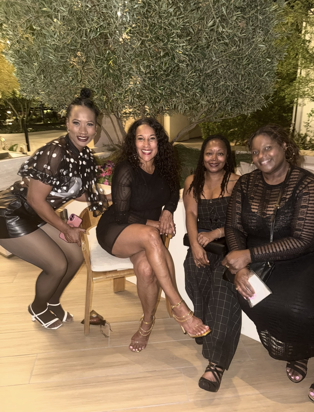 Four women in candid conversation at an evening WEPN event